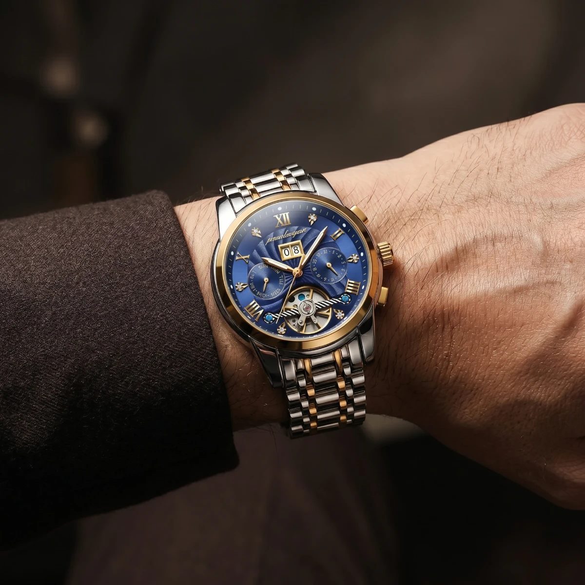 poedagar-1408-vision POEDAGAR 1408 two-tone silver and gold watch with a textured blue dial and open-heart movement, worn on a wrist against a dark brown sleeve.