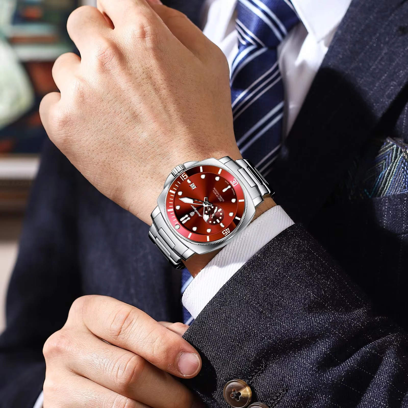 Man wearing POEDAGAR 873 Quartz Analog Watch with red dial and stainless steel bracelet.