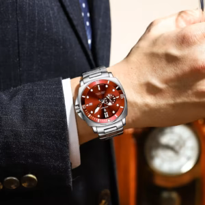 Man wearing POEDAGAR 873 Quartz Analog Watch with red dial and stainless steel bracelet.